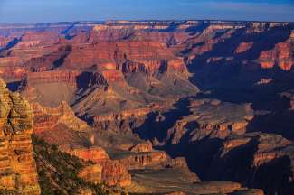 Während des Sonnenuntergangs treten die roten Farben des Grand Canyons in den Vordergrund.