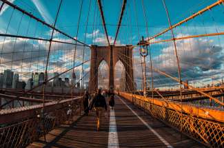 Laufen Sie über die Brooklyn Bridge und genießen die schöne Aussicht auf Manhattan.