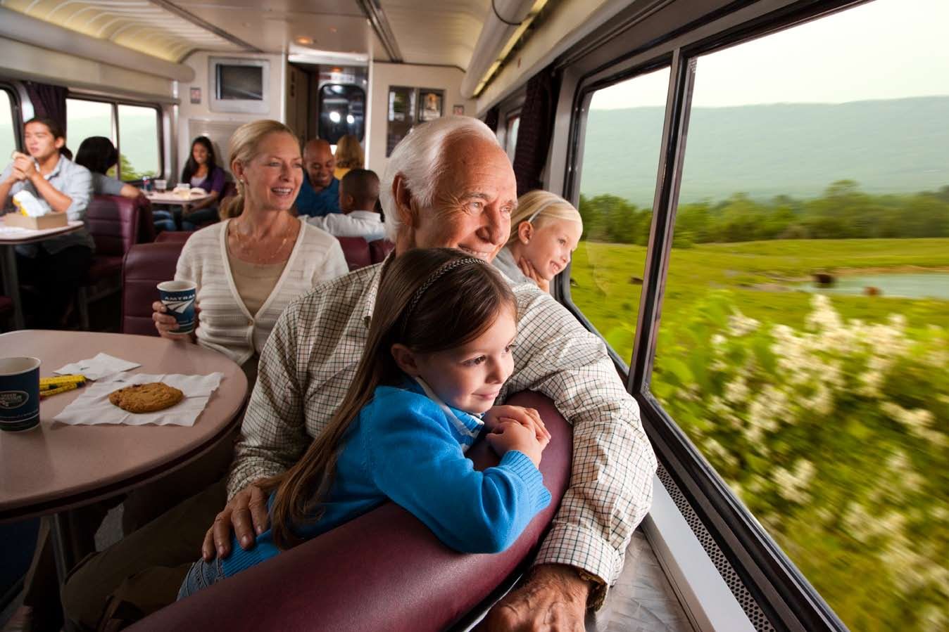 Ребенок едет на поезде с бабушкой. Пассажиры в поезде. Путешествие на поезде семьей. Семья в поезде. Семья путешествует на поезде.